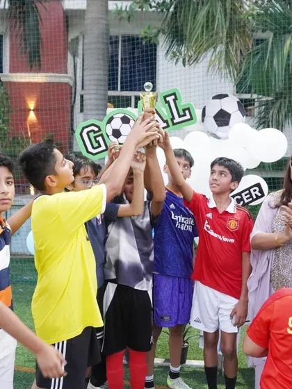 For our sports-themed parties, we use the outdoor turf for some real action. This moment of triumph, with the winning team hoisting their trophy, is what makes these celebrations so special.