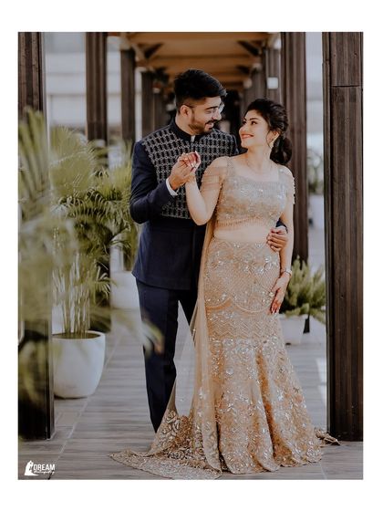 A classic, full-length portrait of the engaged couple, showcasing their beautifully coordinated outfits and the elegant venue.