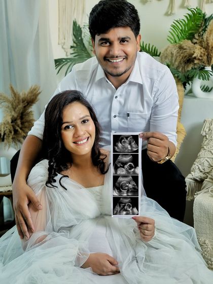 A happy couple announcing their pregnancy with a sonogram strip. Their joyful smiles say it all. This is a timeless way to share your exciting news.