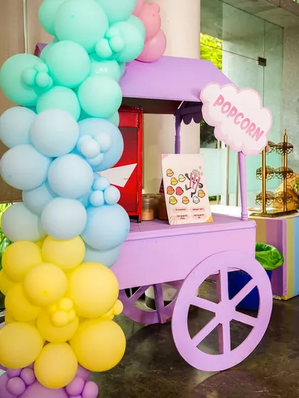 A purple popcorn cart adds another splash of color and a tasty snack option to the Hello Kitty party.