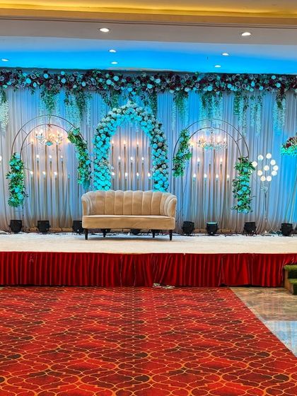 A modern and fresh stage design at Sky Banquet hall in Kharghar. We used a green and white floral theme with minimalist arches and soft lighting to create a sophisticated and stylish look.