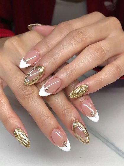 A modern and artistic take on the French manicure, featuring 3D gold chrome accents over classic white tips on stiletto nails.