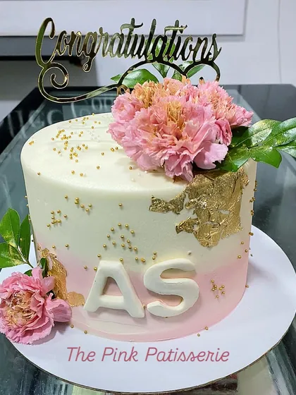 A "Congratulations" cake with initials, perfect for celebrating a work win or engagement. The design features an elegant pink ombre, gold leaf, and fresh carnations.