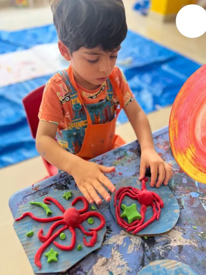 It’s not just about paint. Here, a young artist concentrates on sculpting with clay, developing fine motor skills and bringing his imagination into three dimensions. We provide a variety of materials to let children explore different forms of texture and expression.