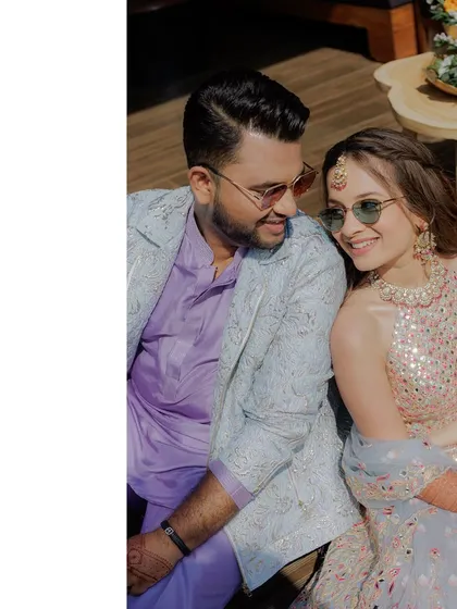 Another lovely shot of the couple enjoying their Haldi. The groom's light blue jacquard jacket contrasts beautifully with his lilac kurta, showing the power of tone-on-tone layering.