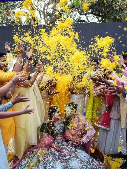 A shower of yellow petals rains down on the couple during their Haldi ceremony, creating a picture-perfect moment of joy.