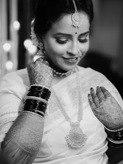 A timeless black and white bridal portrait. This image of Sayali focuses on her serene expression and the beautiful details of her jewelry and mehndi, creating a classic and elegant photograph.