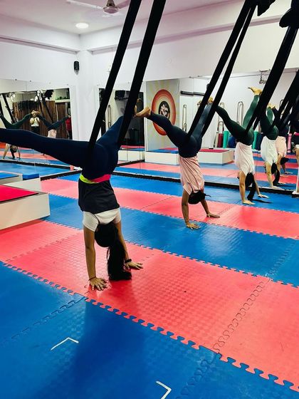 An inverted handstand supported by the aerial hammock. This is a safe way to practice inversions, getting all the benefits without putting pressure on the neck or spine.