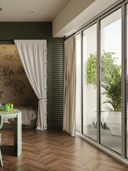 A view from the play area towards the balcony, showing how the room is filled with natural light. The herringbone wood flooring and sage green furniture create a stylish yet child-friendly space.