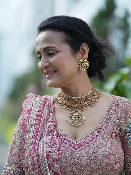 A candid, smiling profile. The makeup is soft and understated, letting her natural grace and the beauty of her traditional outfit be the focus.