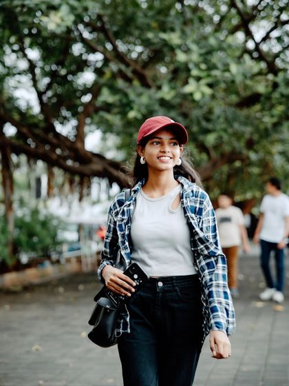 A candid moment captured as she walks. The focus is on her smile and the movement, creating a dynamic and lively image.