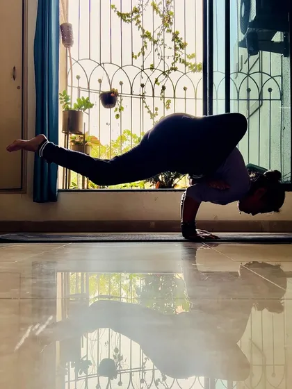 A moment of quiet strength, finding balance in an arm-balancing pose against the light. I wasn't naturally strong, so I know the journey of building strength from the ground up. It's about consistent practice and believing in your own power.