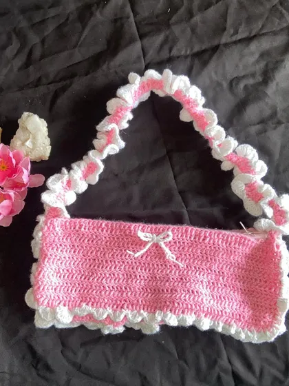 Front view of the handmade pink ruffle bag. The little white bow in the center is my favorite part and completes the coquette vibe.
