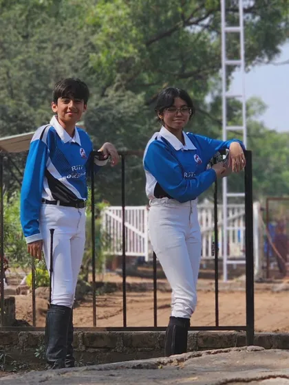 Two of our young riders looking sharp in their team jerseys. They are standing by the arena, ready to cheer on their teammates and learn from watching others ride.