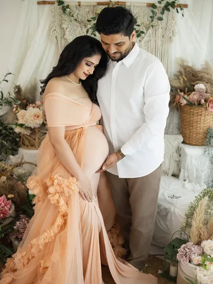 A quiet, intimate moment between an expecting couple. The focus is on their hands and the baby bump, a simple yet powerful image of connection and anticipation.