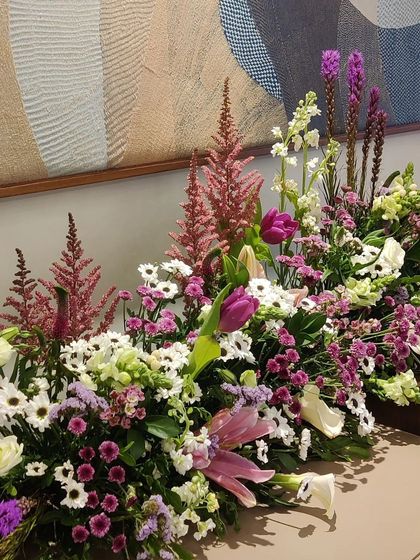 A lush and textural floral arrangement. We combined tulips, astilbe, and daisies in shades of pink, purple, and white to create a beautiful, sprawling centerpiece that feels both wild and curated.