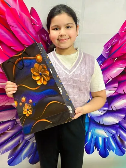 Hard work pays off. This young achiever proudly holds her gift after conquering challenges in our hula hoop class.