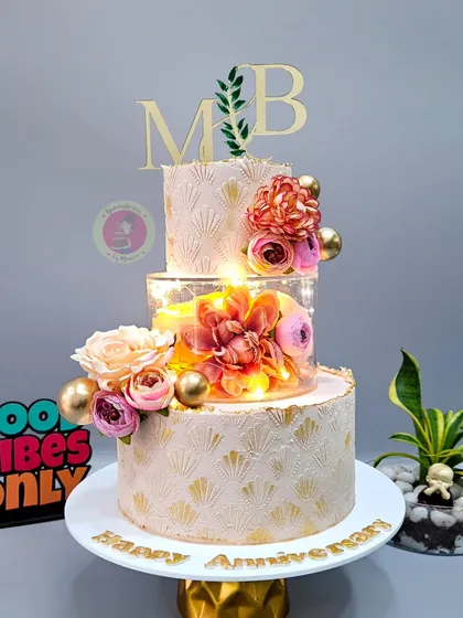 For a grand anniversary, we created this three-tier masterpiece with a lit-up separator and delicate floral arrangements. It’s not just a cake; it’s a centerpiece that glows with elegance.