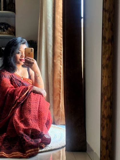 A quiet moment of reflection, draped in a beautiful red saree, captured in a mirror selfie.