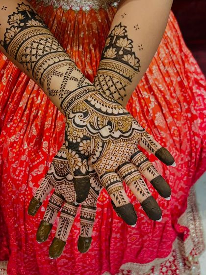 This design combines floral work with intricate check patterns. The dark fingertips provide a beautiful contrast, making the detailed work on the hands stand out.