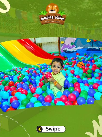 A happy boy enjoying our vibrant ball pit. It's one of the most popular spots in our play zone, perfect for hours of fun.