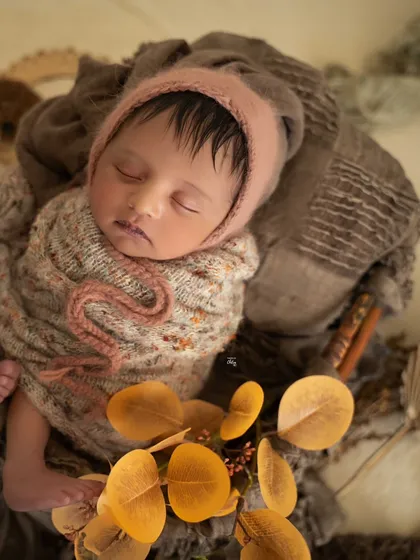 A close-up portrait showcasing the baby's perfect features and the soft, fuzzy texture of the bonnet.