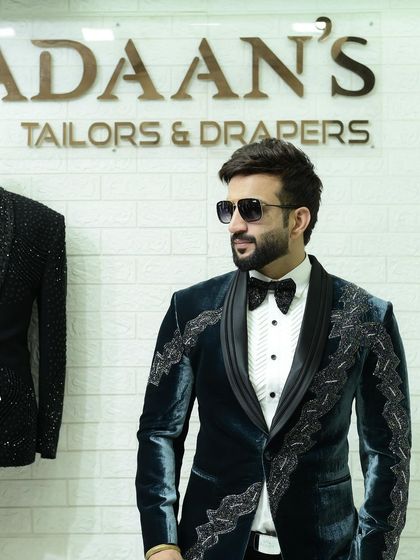 A client looking cool and confident in our teal velvet tuxedo. The jacket features intricate black beadwork, offering a unique and modern take on formalwear.