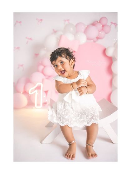 A joyful, giggling girl celebrating her first birthday. The pink and white theme is so classic and sweet.