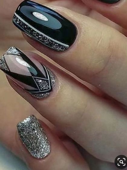 A close-up of a geometric design using black polish and packed silver glitter. This shows how glitter can be used to create sharp, graphic, and modern nail art.