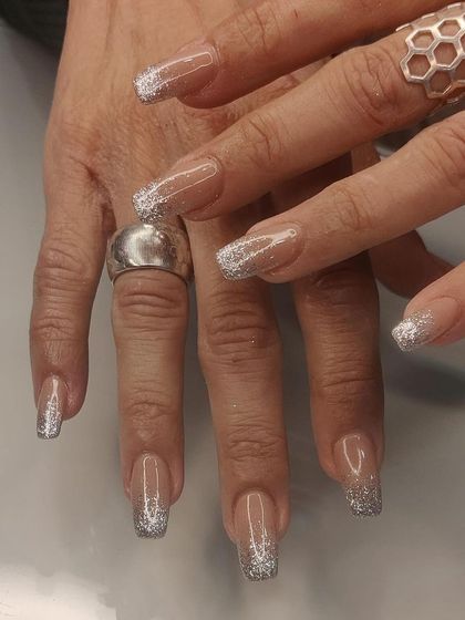 A full set of long, clear square extensions with a sparkling silver glitter fade from the tip.