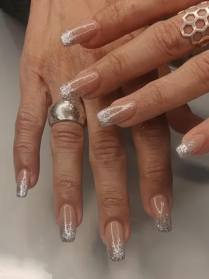 A glamorous silver glitter fade on long, clear square extensions, perfect for a party or celebration.
