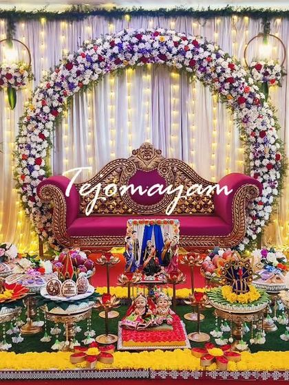A closer look at the centerpiece of a baby shower decor, featuring a Pattada Gombe swing setup and an ornate pink throne under a floral arch.