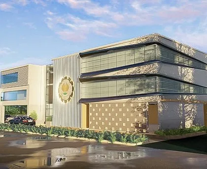 An angled perspective of the ICAI Goa building, showing the interplay of different materials and volumes. The design includes covered parking and landscaped entryways, focusing on a functional and pleasant experience for both staff and visitors.