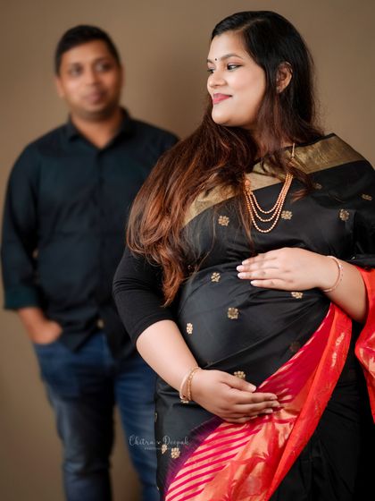 A beautiful portrait focusing on the mom-to-be, with her partner slightly out of focus in the background, symbolizing his supportive presence.
