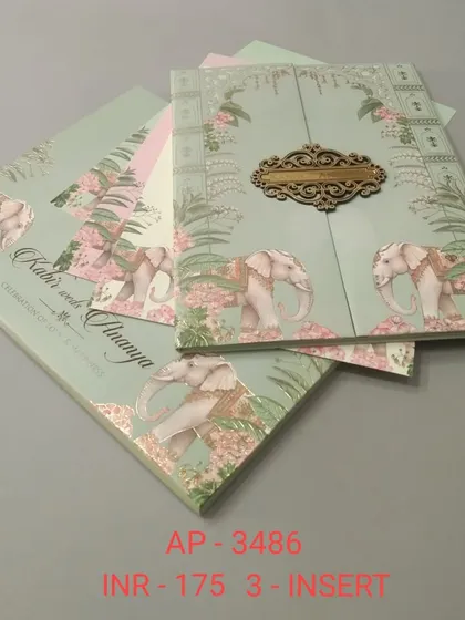 This gate-fold invitation in a soft mint green features a pattern of royal elephants amidst tropical foliage. The wooden clasp adds a touch of elegance and secures the three inserts inside.