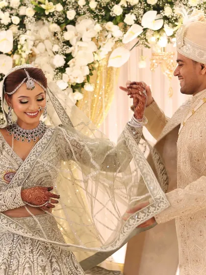 A candid, happy moment between the bride and groom. Her smile is infectious, and the diamond jewellery sparkles as she interacts with her partner.