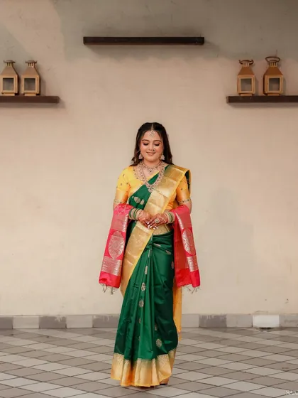 A full-length shot of a bride in a yellow and green saree, looking poised and ready for her ceremony.