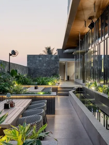 Sunken seating areas on the terrace are surrounded by lush planters and integrated lighting, creating intimate zones for dining.