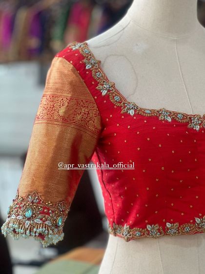 The front of the red blouse, with a sweetheart neckline and floral butis.