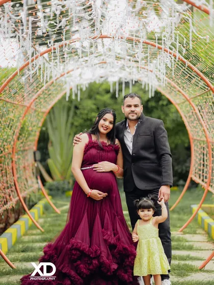 A complete family portrait in a whimsical, fairy-light tunnel. This image captures the magic of the moment, with the whole family dressed up to celebrate the new arrival.