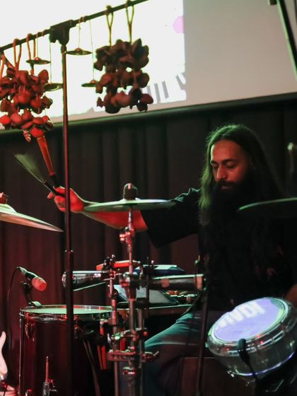 A drummer in action during a Fête de la Musique performance. The close-up shot highlights the instrumental skill and rhythmic energy that drives our concerts.