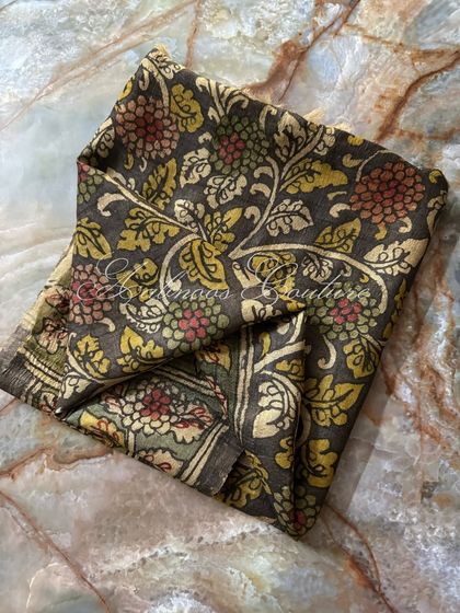 A folded view of the charcoal grey silk dupatta, focusing on the dense and intricate floral pattern that covers the fabric. This is a hallmark of traditional Srikalahasti art.