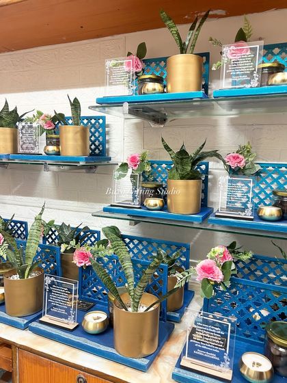 The gratitude hampers arranged on glass shelves, creating a stunning visual display of blue, gold, and green.