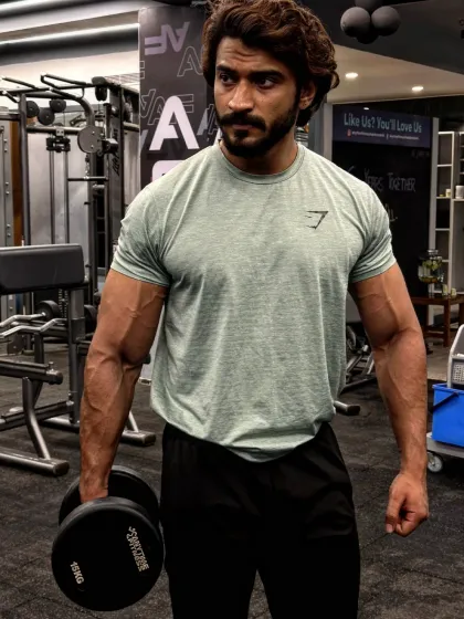 The hustle for muscle is real. Holding a 15kg dumbbell, this shot captures the everyday grind in the gym. Every single workout, from light to heavy, is a step towards your fitness goal.