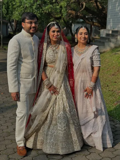 A precious family moment. The bride stands radiant in her ivory and red lehenga, her soft glam makeup looking flawless.