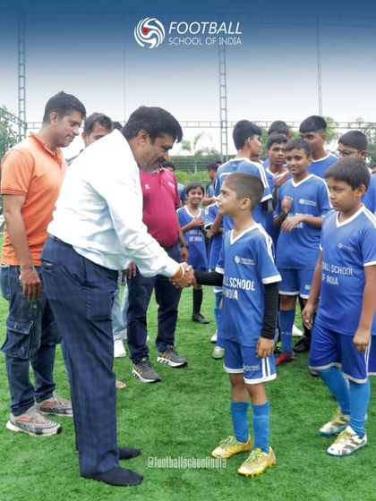 A senior member of our community welcomes a young player to the new turf in Pune. This handshake represents the connection and mentorship that are central to the FSI family culture.