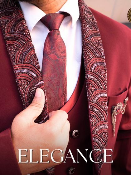Elegance. A close-up of the maroon suit, focusing on the detailed lapel, matching tie, and perfect tailoring.
