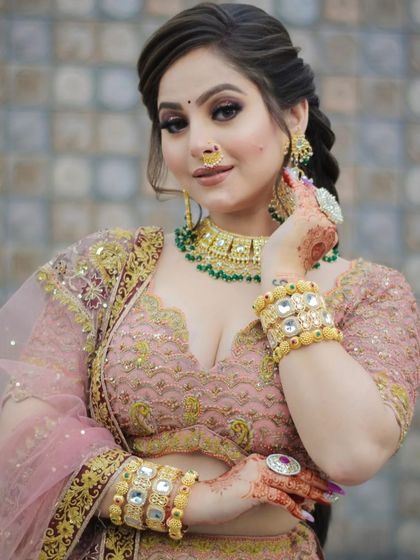 This client is ready for a party with her glamorous makeup. The look features a defined smokey eye and a soft pink lip, paired with a beautiful braided hairstyle.