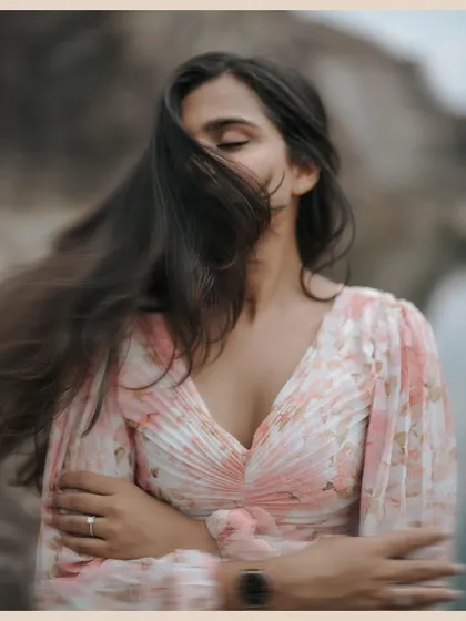 The wind catching her hair as she closes her eyes in a moment of peace. This artistic, moody portrait from a mountain pre-wedding shoot focuses on feeling and atmosphere.