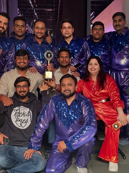 A celebratory moment with the entire cast and crew, holding our award after a successful corporate show. Teamwork is the key to creating unforgettable events.